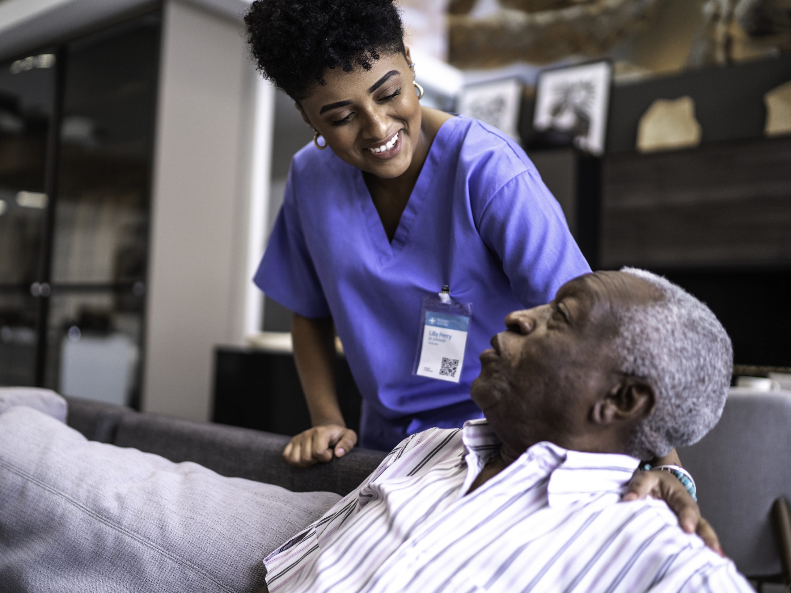 Female nurse taking care of a senior man at home